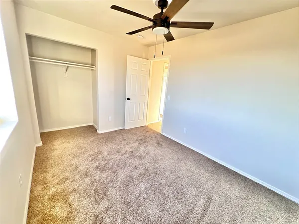 an empty room with a empty space and a ceiling fan