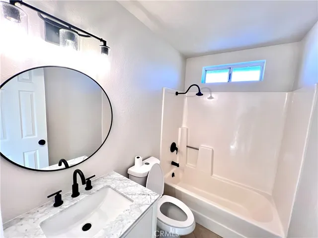 a bathroom with a sink a mirror a toilet and bathtub