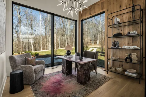 a open kitchen with granite countertop a stove a sink a dining table and chairs with wooden floor