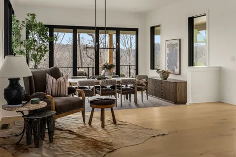 a living room with furniture a large window and potted plant