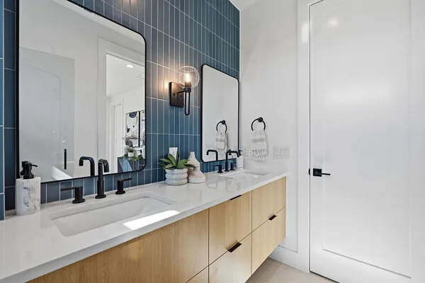 a bathroom with double vanity sinks and a mirror