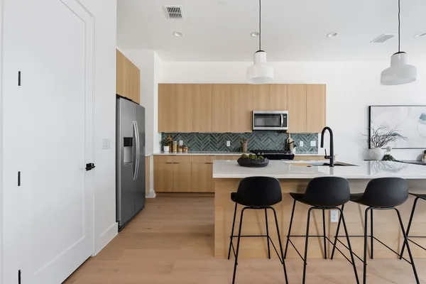a kitchen with stainless steel appliances granite countertop a sink and a refrigerator