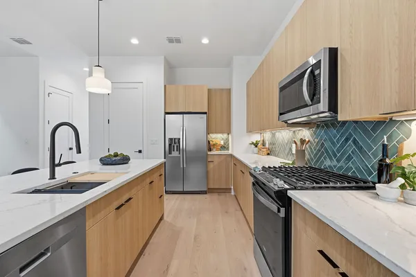 a kitchen with stainless steel appliances kitchen island a sink stove and refrigerator