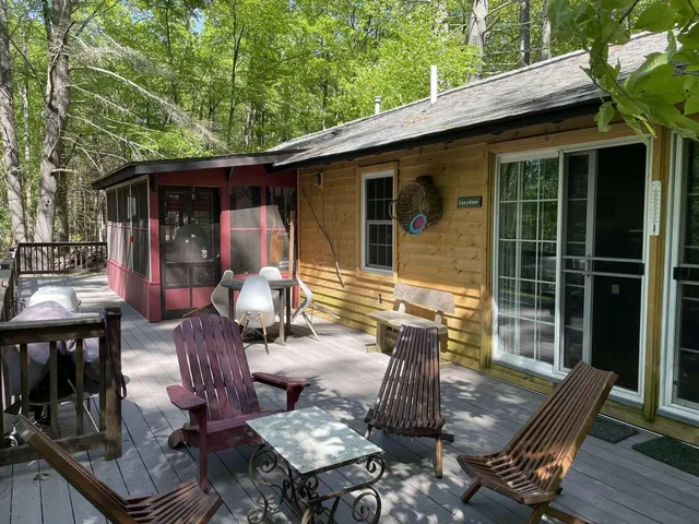 a view of a patio with table and chairs with wooden floor and fence