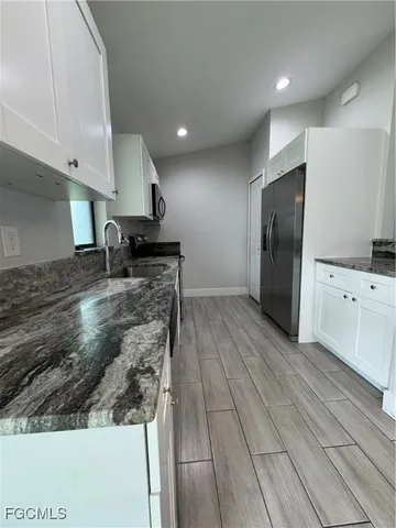 a kitchen with stainless steel appliances granite countertop a sink a stove and a refrigerator