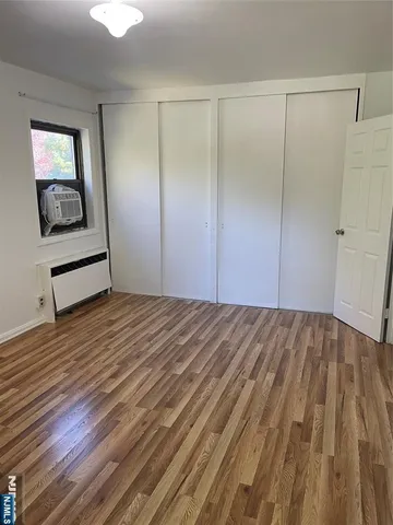 a room with a bed and wooden floor