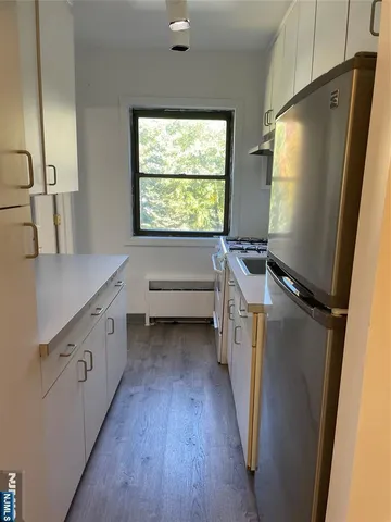 a kitchen with sink a refrigerator and window