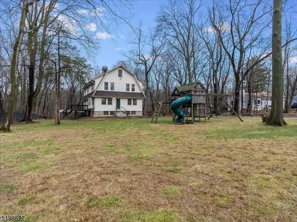 a view of a house with a yard and sitting area