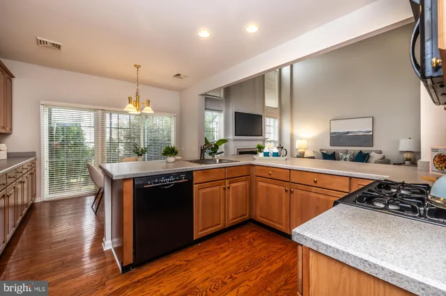 a large kitchen with stainless steel appliances granite countertop a stove a sink and a microwave