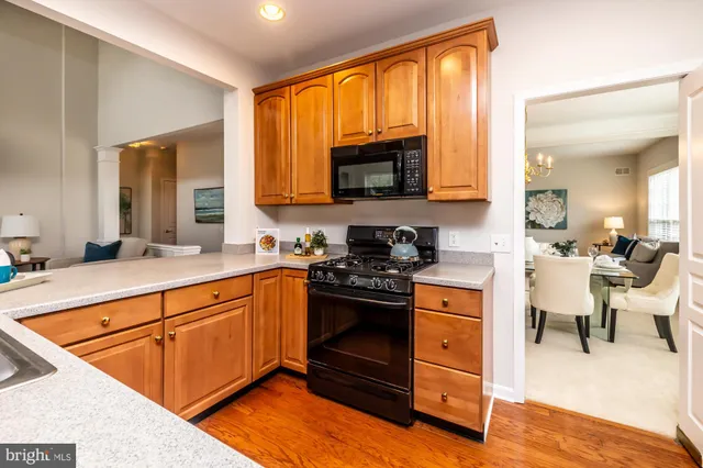 a kitchen with stainless steel appliances granite countertop wooden cabinets a stove top oven a sink and dishwasher