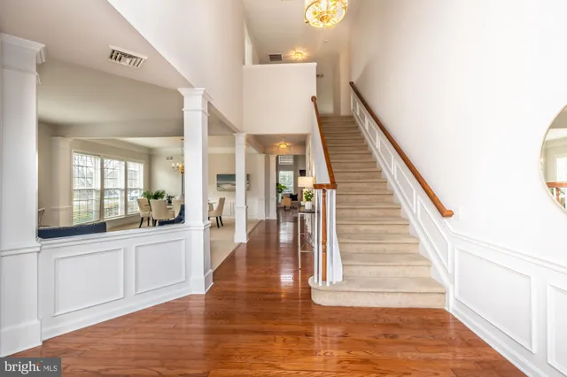 a view of a hallway with wooden floor and staircase