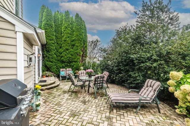 a front view of a house with a garden and trees
