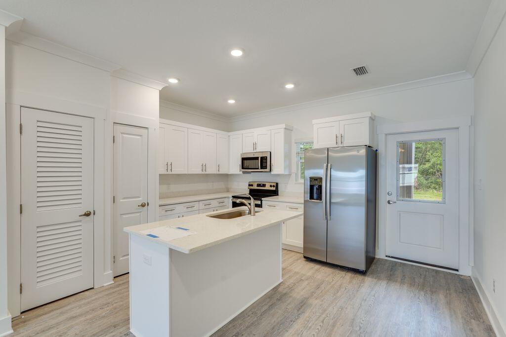 a kitchen with a refrigerator a sink and cabinets