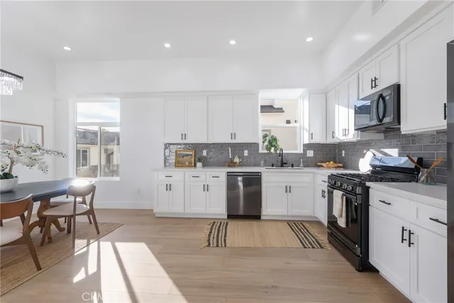 a kitchen with a sink window and stainless steel appliances