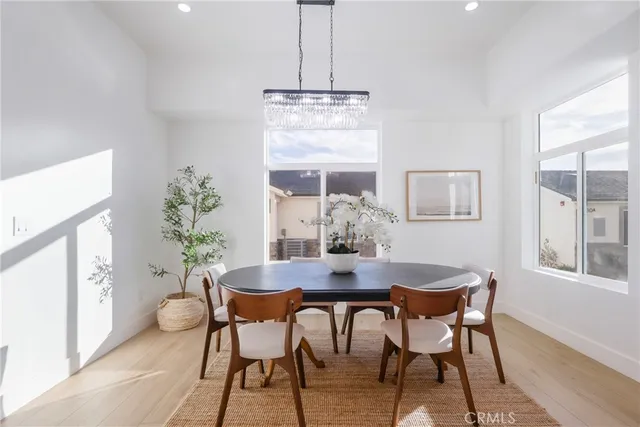 a dining room with furniture a chandelier and wooden floor