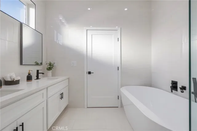 a bathroom with a tub a sink and mirror
