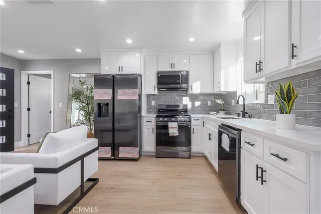 a kitchen with stainless steel appliances granite countertop a refrigerator sink and cabinets