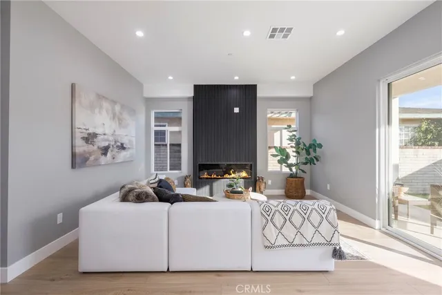 a living room with furniture a large window and potted plant