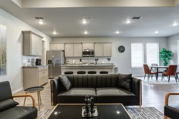 a kitchen with a refrigerator and chairs
