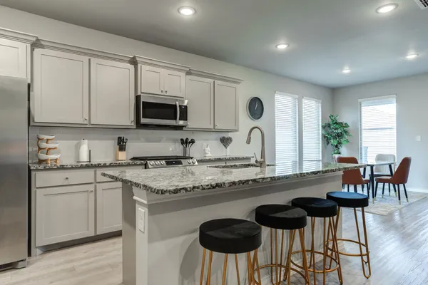 a kitchen with granite countertop white cabinets and stainless steel appliances