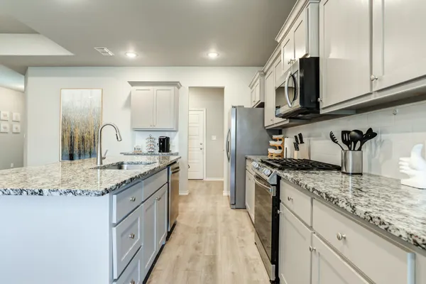 a kitchen with stainless steel appliances granite countertop a sink stove and refrigerator