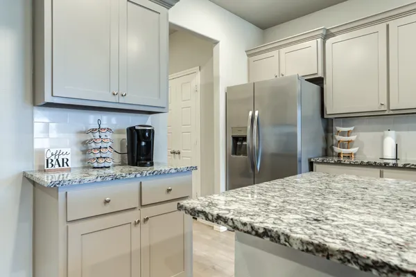 a kitchen with stainless steel appliances granite countertop a sink refrigerator and cabinets