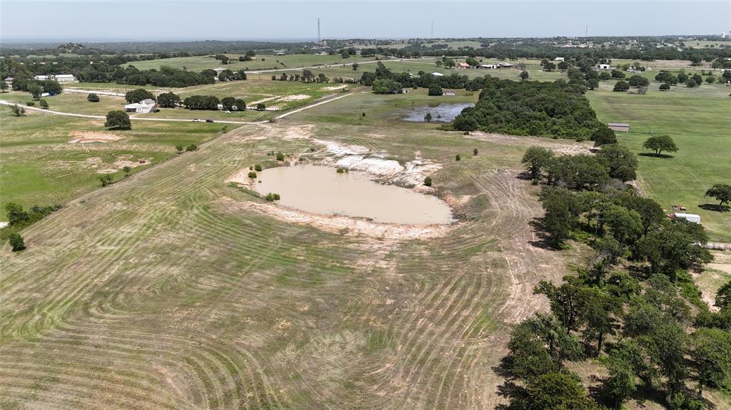8605 West Highway 199 Springtown, TX 76082 - Photo 9 of 23 Expansive land parcel featuring a central pond, surrounding pastures, and a tree line