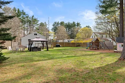 a view of a house with a big yard and large trees