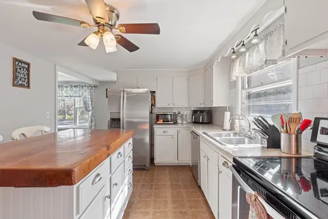 a kitchen with stainless steel appliances granite countertop a sink a stove and a refrigerator