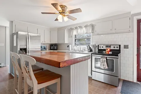 a kitchen with stainless steel appliances granite countertop a stove refrigerator sink and microwave