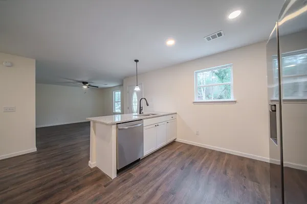 a kitchen with stove and wooden floor