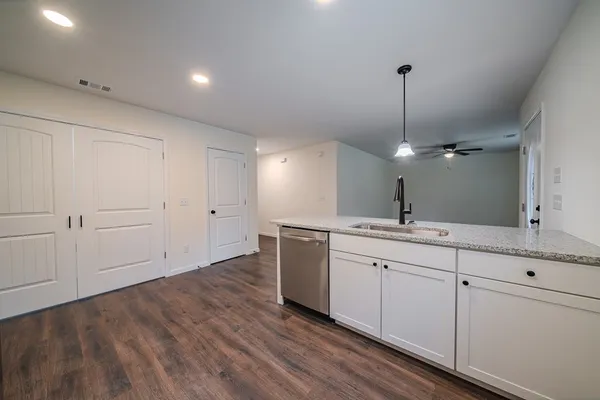 a kitchen with white cabinets and sink