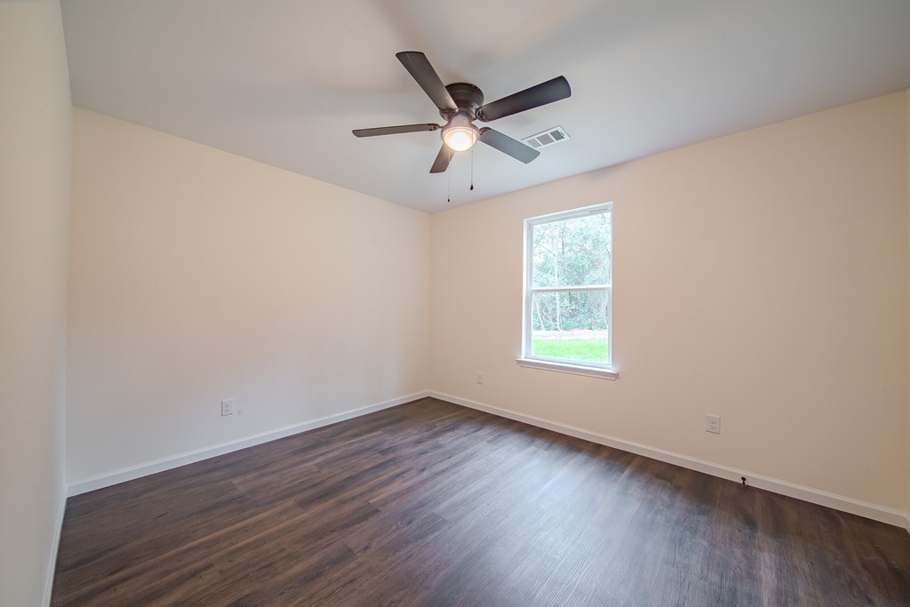4384 Forrest Road Columbus, GA 31907 - Photo 22 of 30 an empty room with wooden floor fan and windows