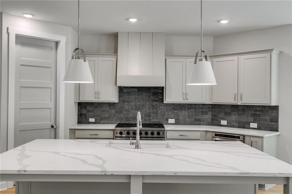 662 Lake Cir Road Buchanan, GA 30113 - Photo 18 of 62 a kitchen with kitchen island granite countertop cabinets and white appliances