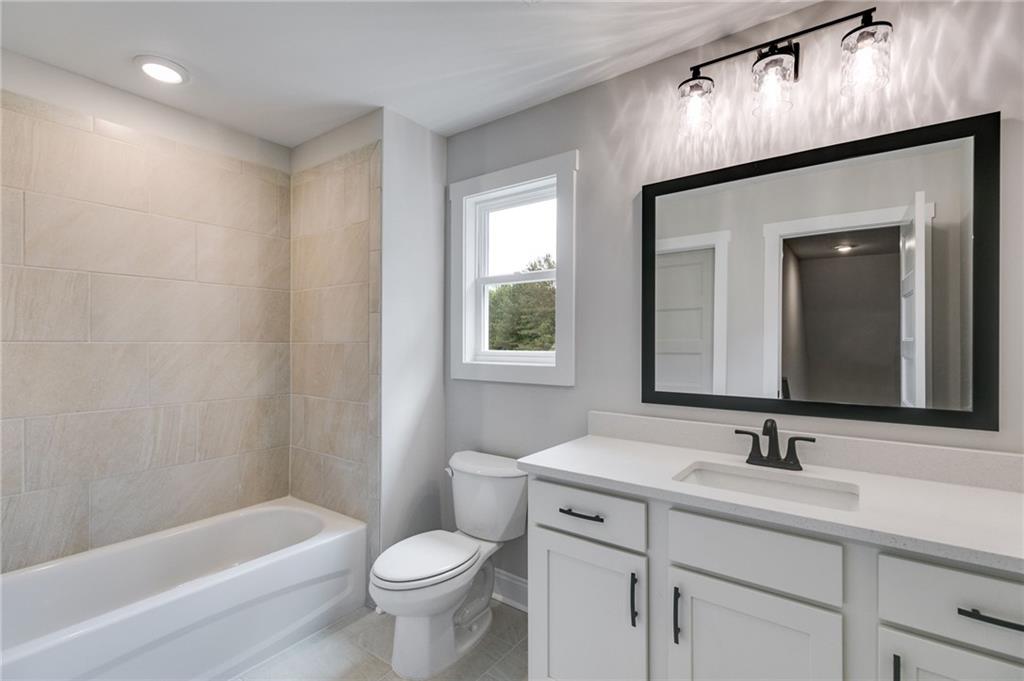 662 Lake Cir Road Buchanan, GA 30113 - Photo 38 of 62 a bathroom with a toilet a sink a bathtub and a mirror