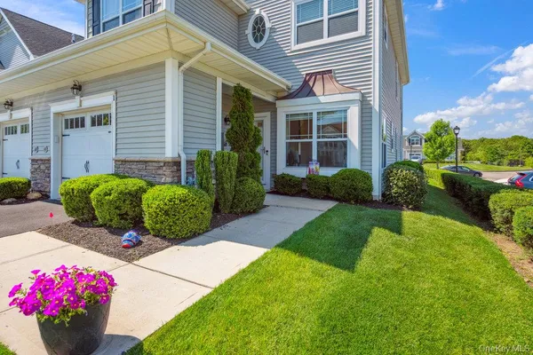 a front view of a house with garden and plants