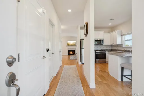 a view of a kitchen with kitchen island wooden floor center island and stainless steel appliances