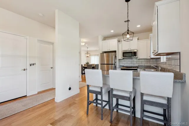 a kitchen with kitchen island white cabinets and stainless steel appliances