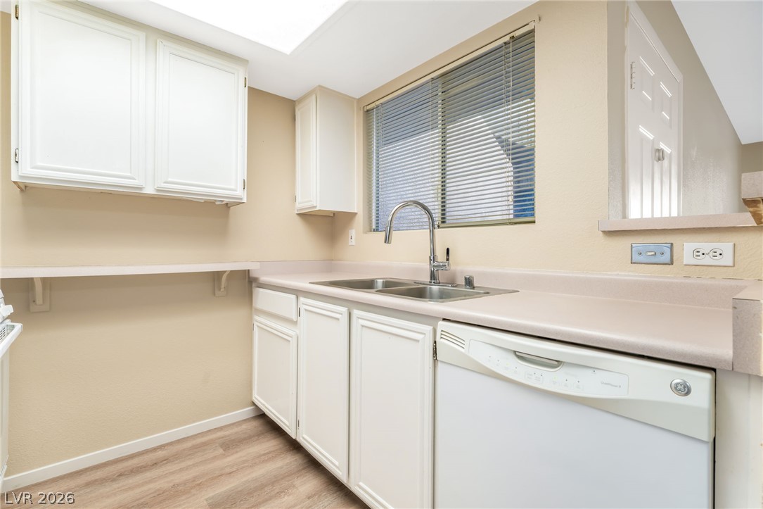 8070 West Russell Road, Unit 1054 Las Vegas, NV 89113 - Photo 8 of 22 Functional kitchen offers ample cabinetry, a double basin sink, and wood-look flooring.