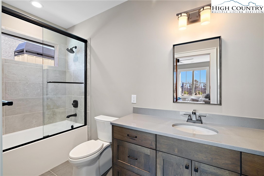 150 Calico Court Boone, NC 28607 - Photo 17 of 50 a bathroom with a granite countertop sink toilet a mirror a vanity and shower