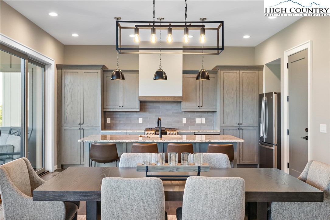 150 Calico Court Boone, NC 28607 - Photo 6 of 50 a kitchen with stainless steel appliances granite countertop a kitchen island a table and chairs in it