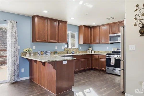 a kitchen with stainless steel appliances granite countertop a refrigerator sink and stove