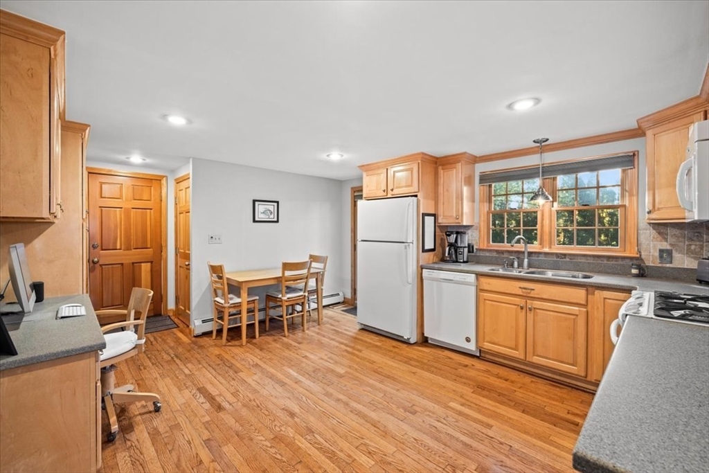 261 Emmett Street Fall River, MA 02721 - Photo 14 of 40 a kitchen with stainless steel appliances granite countertop a refrigerator a stove top oven a sink dishwasher and white cabinets with wooden floor