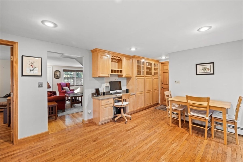 261 Emmett Street Fall River, MA 02721 - Photo 15 of 40 a living room with furniture a dining table and a flat screen tv with wooden floor