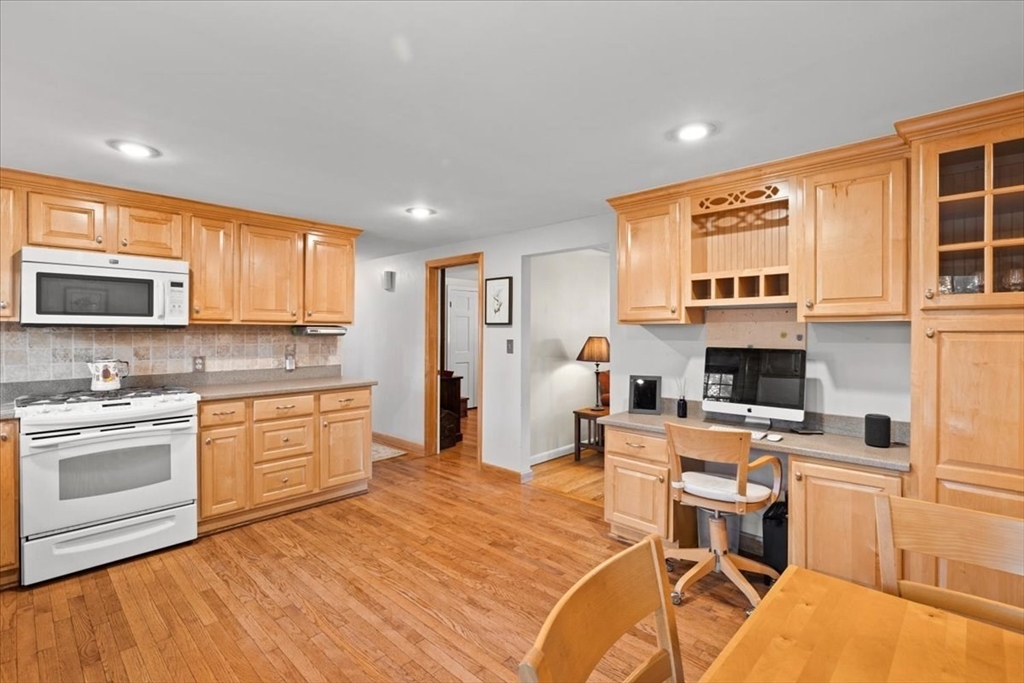 261 Emmett Street Fall River, MA 02721 - Photo 17 of 40 a kitchen with stainless steel appliances granite countertop a stove top oven a sink a dining table and chairs with wooden floor