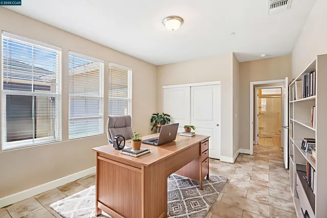 a view of a workspace with furniture and a window