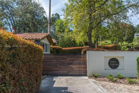a view of a entrance gate of the house and trees