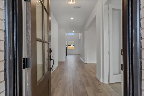 a view of a hallway with wooden floor and stairs