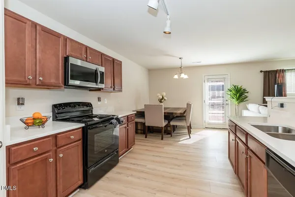 a kitchen with stainless steel appliances granite countertop wooden cabinets a stove top oven a sink and dishwasher