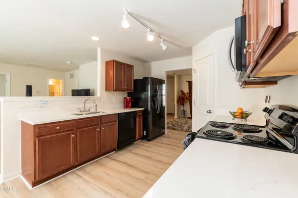 a large kitchen with stainless steel appliances kitchen island granite countertop a sink and a refrigerator